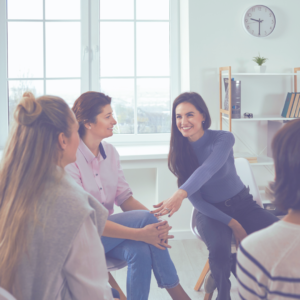 a mom talking with a group of other moms in a supportive situation