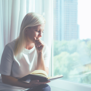 mom sitting by window and reading her Bible