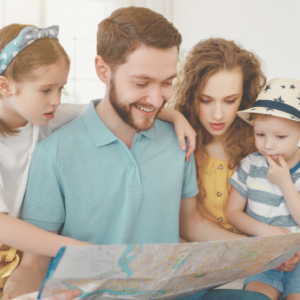 family with two kids looking at a map to plan a family vacation